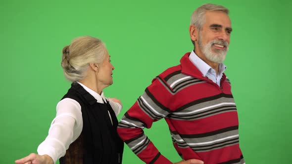 An Elderly Couple Stretches While Smiling at Each Other - Green Screen Studio