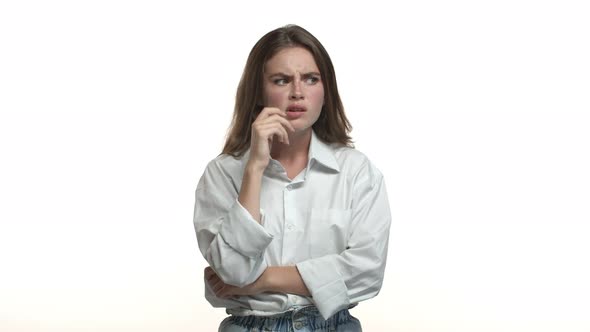 Video of Young Attractive Female Model in White Shirt Looking Puzzled Thinking About Something and