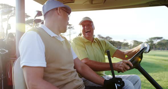 Two Golfers Laughing Together in their Golf Buggy