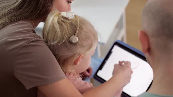 Kid with Cochlear Implants Playing with Tablet Pc at Home