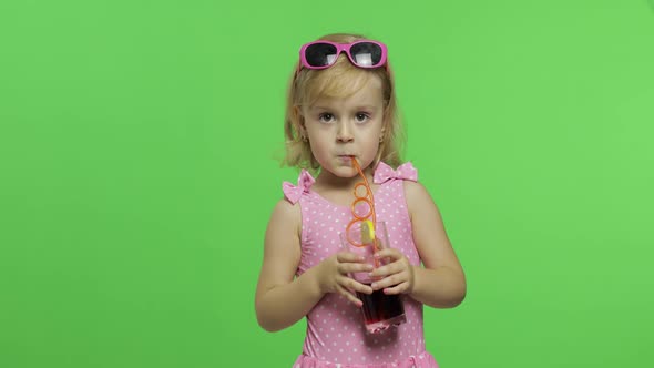 Child in Pink Swimsuit Drinks Juice Cocktail with Drinking Straw. Chroma Key