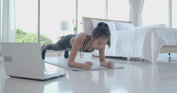 Asian woman give up stop plank exercise drop body on mat with laptop