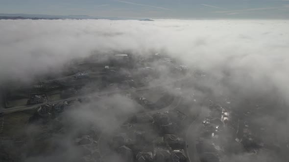 Wide angle drone footage through the cloud line on a bright sunny morning over Folsom, USA with scat