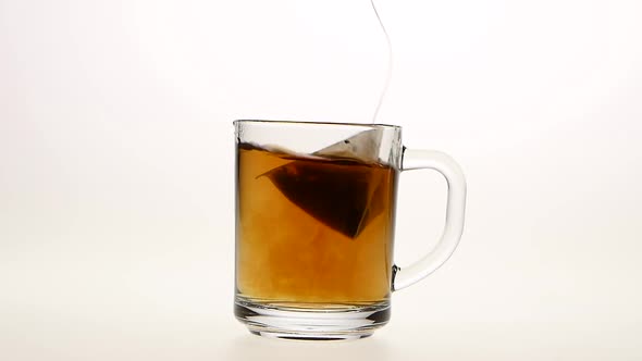 Pyramid Tea Bag in Сup with Hot Water, White Background