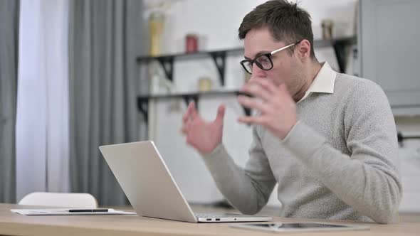 Young Man Shocked By Loss on Laptop