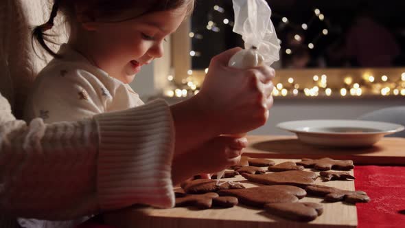 Mother and Daughter Decorating Gingerbread at Home