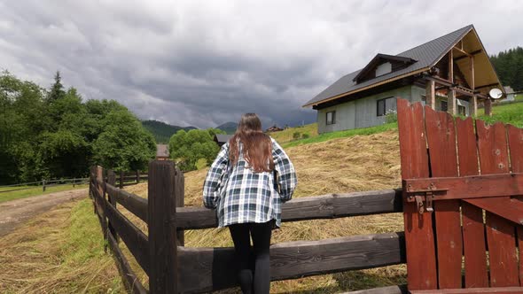 A Young Attractive Caucasian Female Sitting on a Fence