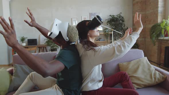 Multiethnic Couple Playing Video Game with VR Glasses at Home