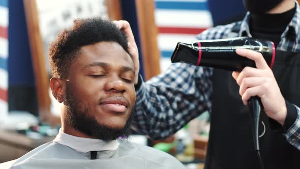 Barber Using Hairdryer While Doing Haircut to Male Client