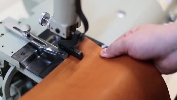 Man Works on Leather Skiving Machine. Use To Bevel the Edges and To Split Strips of Leather To