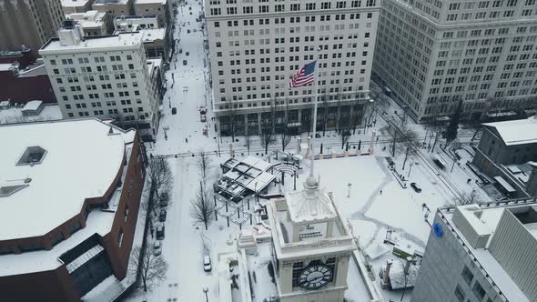 American Flag Waving Over Snow Covered Pioneer Square in Portland During Winter