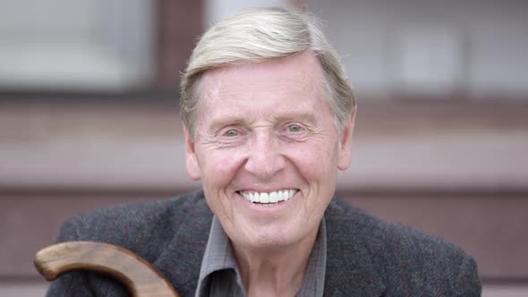 Elderly man smiles while looking at camera