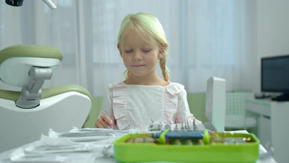 Little Girl Counts Instruments on the Table