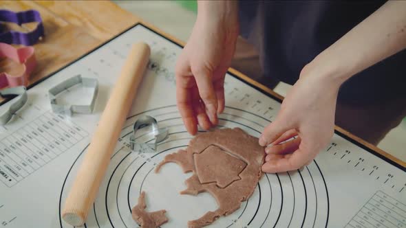 Young Caucasian Woman Cuts Out Cookies From a Dough at Home Kitchen