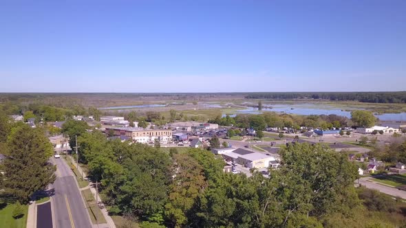 Forward panning aerial of church tower and town of Montague, Michigan