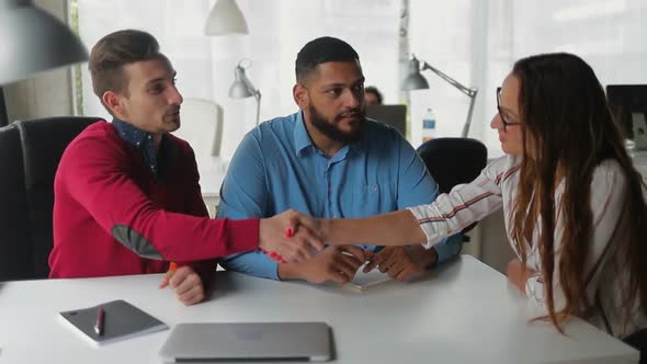 Confident Young People Shaking Hands at Office