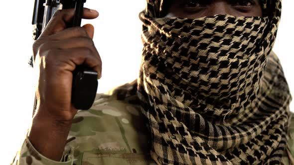 Terrorist holding machine gun against white background