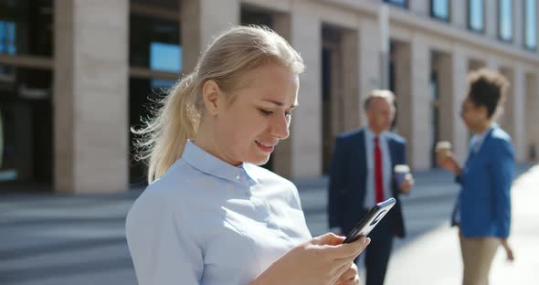 Successful Businesswoman Using App Technologies on Smartphone During Lunch Break Outside Office