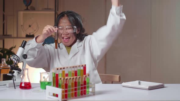 Excited Young Asian Scientist Girl With Dirty Face Mixes Chemicals In Test Tube