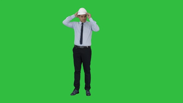 Young construction worker in hard hat on gray background