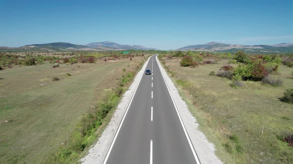 Empty Asphalt Road on the Plateau Between Green Fields Highland Way Aerial View