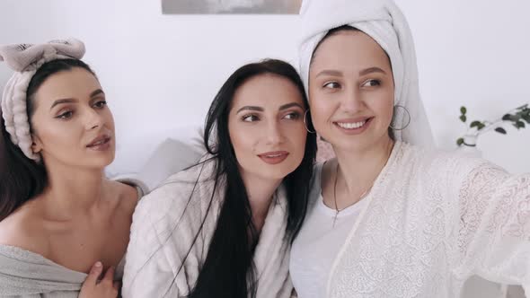 Three Pretty Girlfriends Are Taking Selfies and Doing Makeup in a Bedroom
