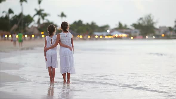 Adorable Little Kids Walking on the Beach with Beautiful Colorful Sunset