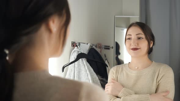 Young and Happy Brunette Female in Clothes Store Smiling and Choosing New Things