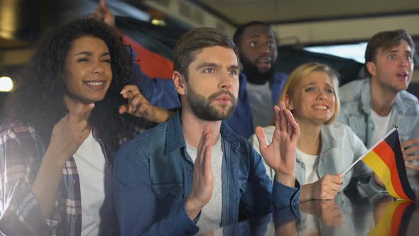 Fans Waving German Flag, Watching Sports Program in Bar, Upset About Losing Game