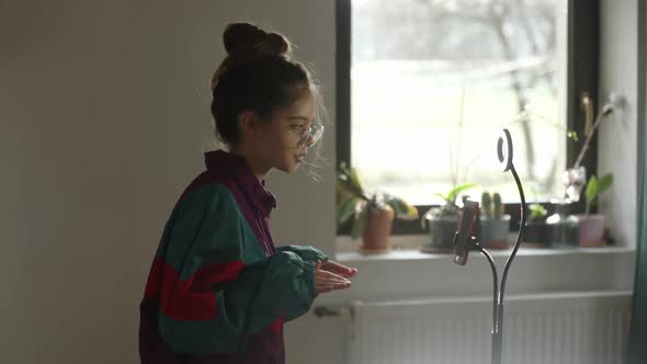 young influencer girl records video on her phone for social media at home