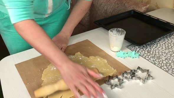 A Woman Rolls Out A Lump Of Dough With A Rolling Pin.