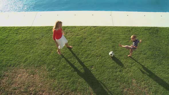 WS OF A MOTHER AND SON PLAYING FOOTBALL