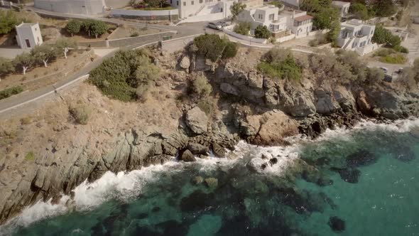 Aerial view of large white villas in front of beach at Ydroussa, Andros island.