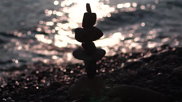 Balanced Pebbles Pyramid on the Beach on Sunny Day and Clear Sky at Sunset