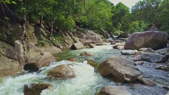 Drone Moves Along Rough River with Rapids Among Tropical Forest