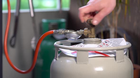 Male hand closes the LPG cylinder. Close-up