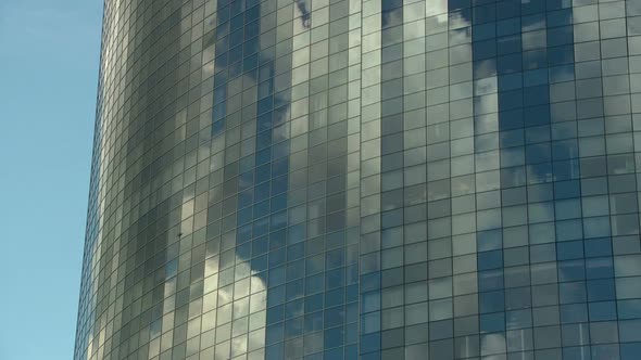 Tall Mirrored Skyscraper Reflects the Clouds Going By in a Timelapse