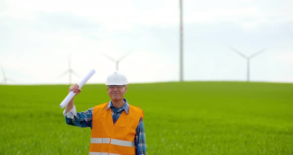 Male Engineer Working While Holding Blueprint