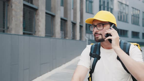 Portrait Delivery Man with Backpack Calling to a Client on the City Street