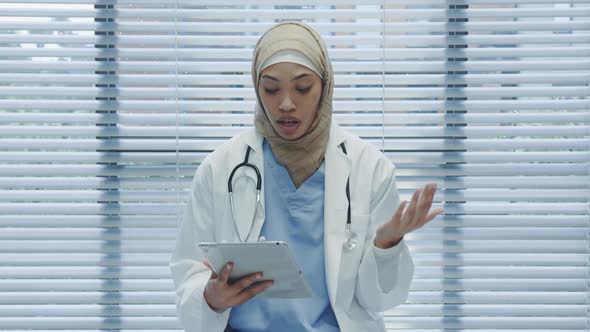 Young female doctor using tablet and talking to camera 4k