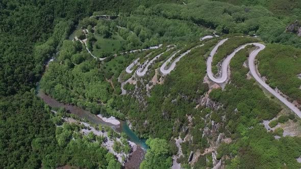 Drone shot. Supercars on a lot of turns heading into the mountain near Paingo, Greece.