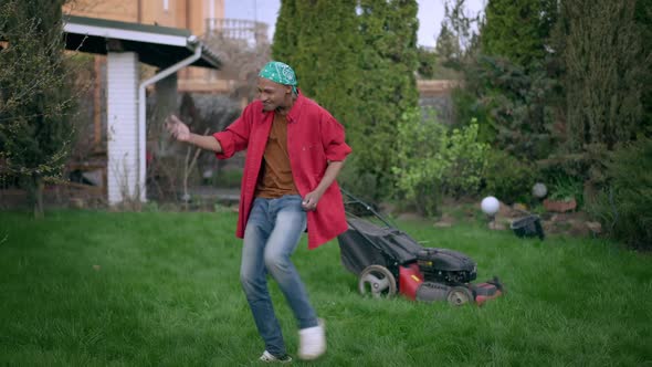 Cheerful Funny Young African American Man Dancing on Summer Lawn in Garden Laughing