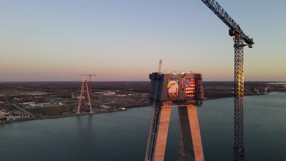 Orbiting view of Gordie Howe Bridge Suspension tower in stunning evening light, left to right aerial