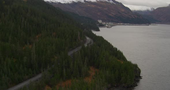 Aerial profile of Troopers helicopter flying over water and past large blue glacier, turns and flies