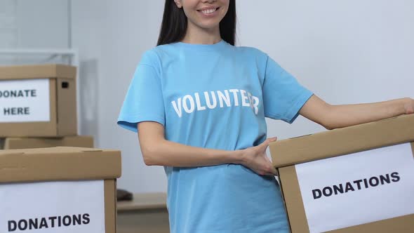 Openhearted Female Volunteer Holding Donation Box and Smiling to Camera, Care