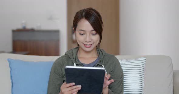 Woman look at the tablet computer and sit on sofa at home