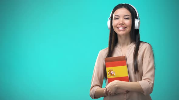 Girl Listening Spanish Audio Lessons in Headset, Book in Hands, Translations