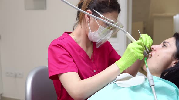 Woman at the Dental Hygienist Getting Professional Tooth Whitening and Ultrasound Cleaning