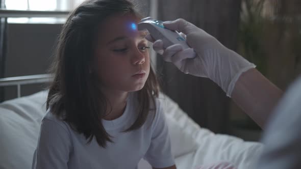 Doctor Measures Temperature of a Child Using an Electronic Thermometer