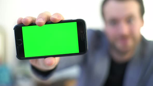 Man showing smartphone display to camera